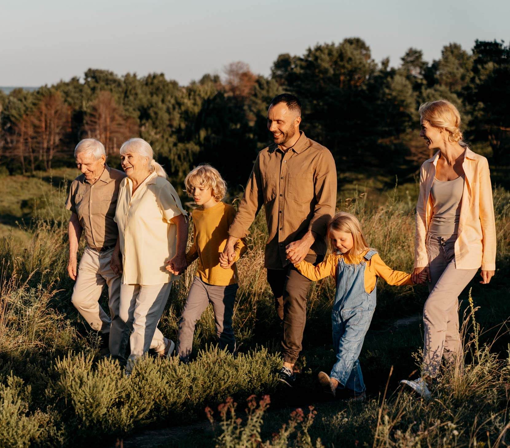 Three generations of a family walking through a field