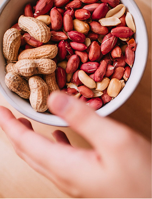 A lady holding a bowl of peanuts